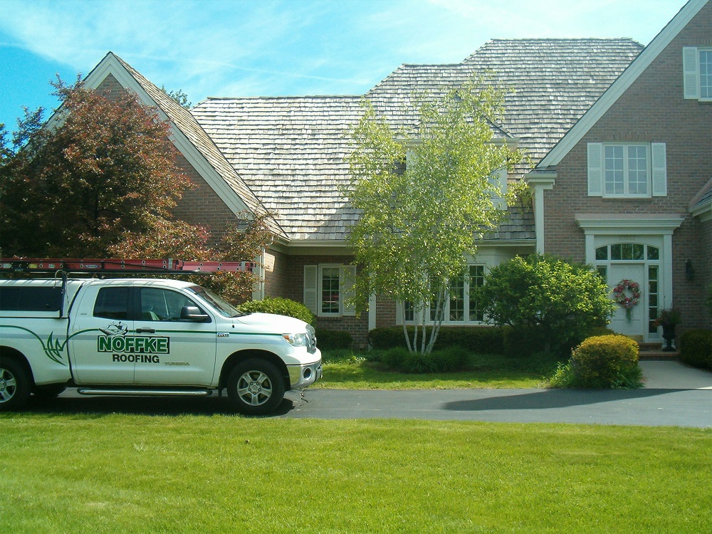 A Noffke Roofing truck outside of a suburban home. 