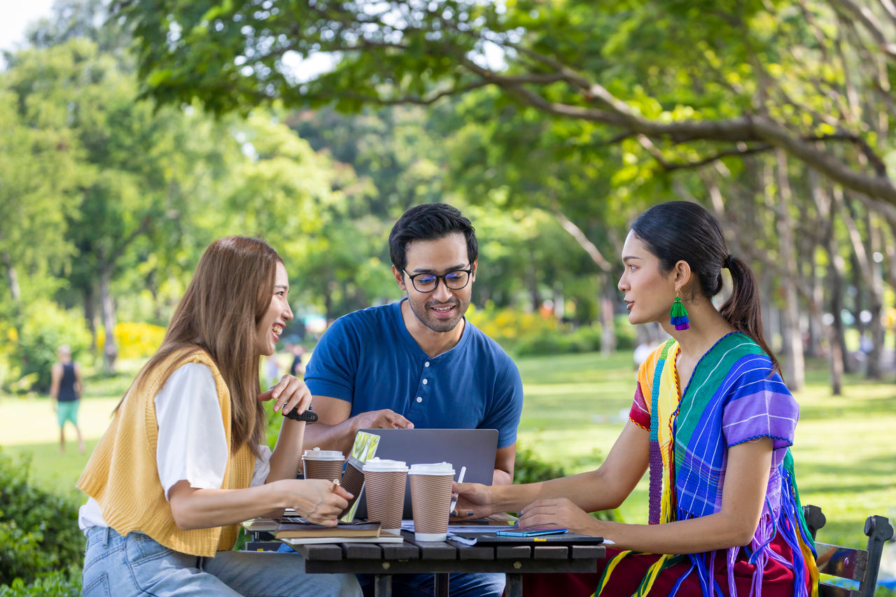 1405414028 Group of college student is meeting and working on thesis and project outside in the university campus garden during summer time