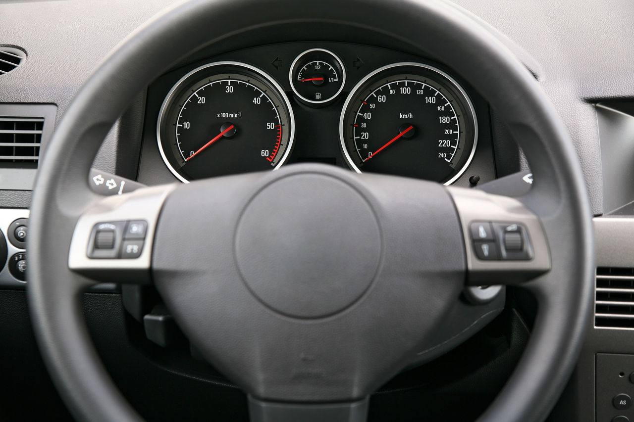Close-up of a car dashboard, focus is on the meters