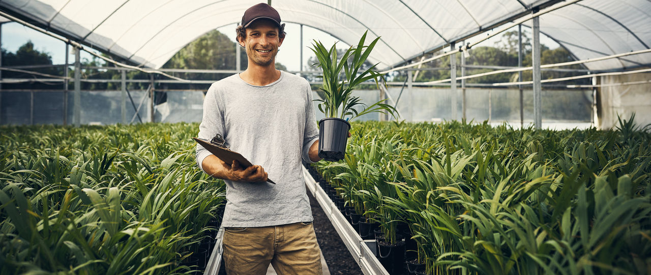 Shot of a young man taking stock of a garden centerâ  s merchandise