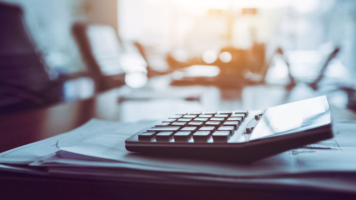 image of calculator on a desk sitting on top of business papers