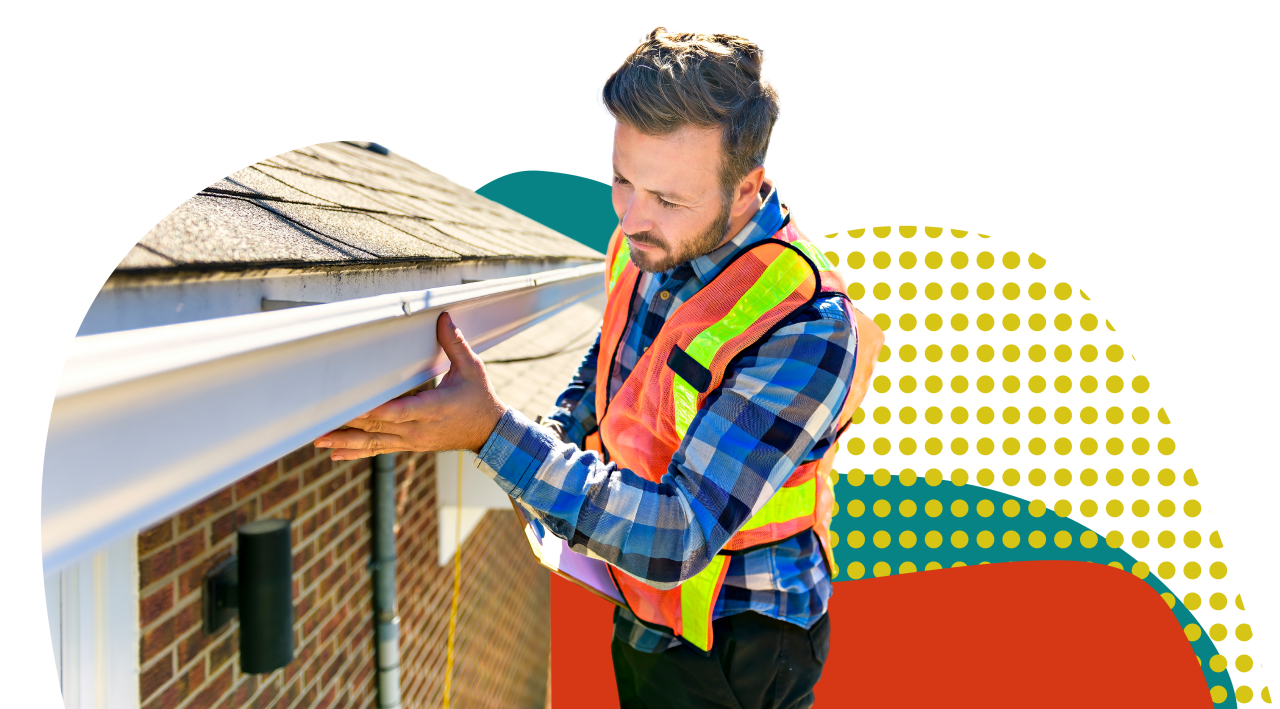 home inspector checking gutters on roof wearing safety vest