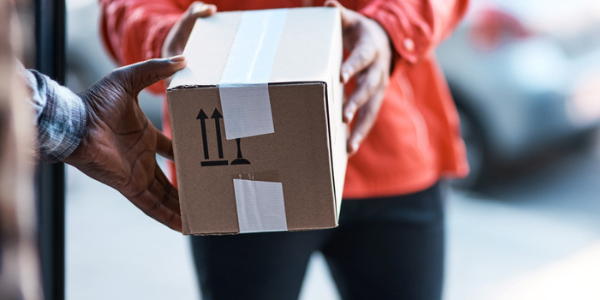 african american man receiving package from african american delivery driver