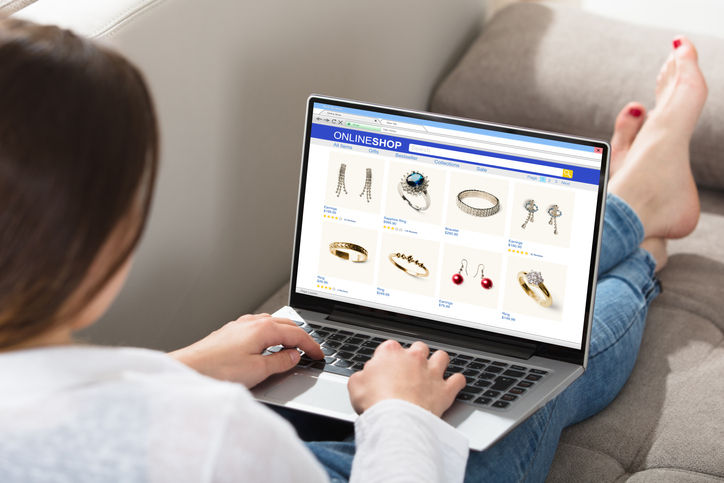 Woman Sitting On Couch Doing Online Shopping On Laptop