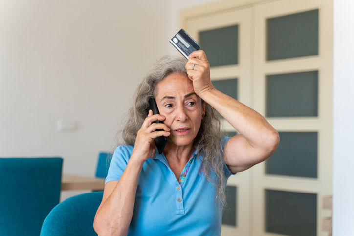 Worried senior woman call bank unable pay by card