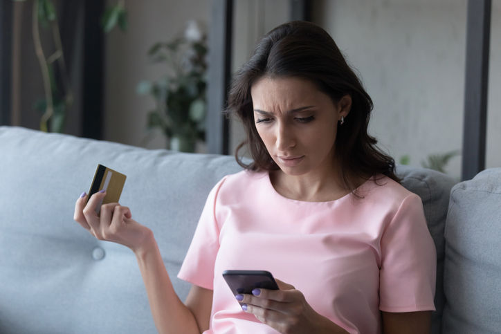 Confused ethnic young woman disappointed with failure making payment online with credit card on cellphone gadget, unhappy indian Arabic female have problems with account security, shopping on web
