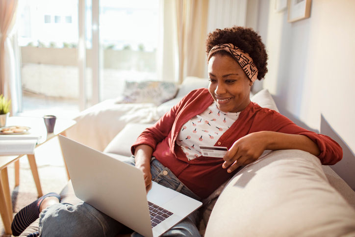 Close up of a young adult woman using her laptop to online shop