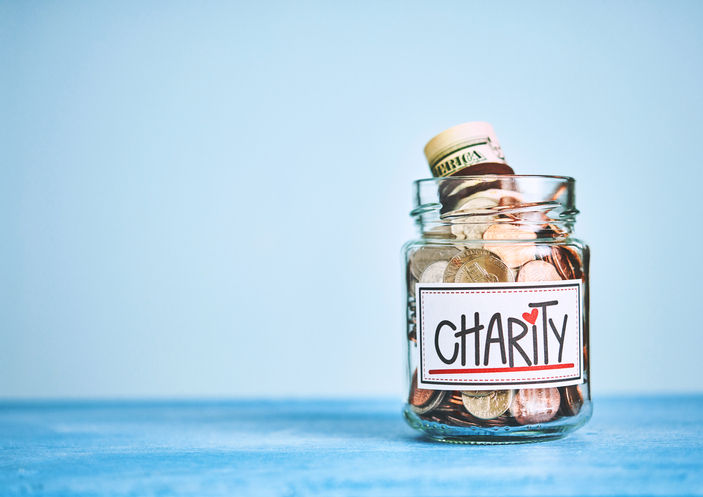 Charity donation money jar with blue background and space for text