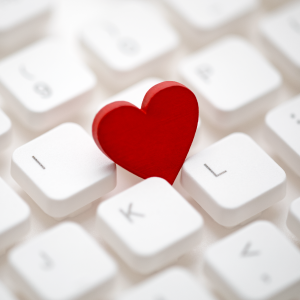 White computer keyboard with red heart between the keys