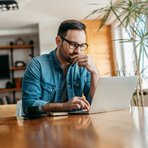 Man sitting at table working on laptop computer