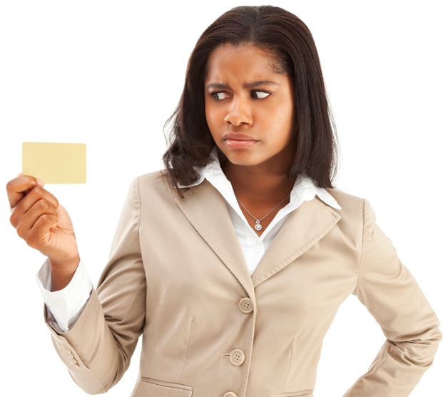 Photo of an attractive young African American holding a blank gold credit card in one hand with a look of disgust and disappointment on her face; isolated on white.