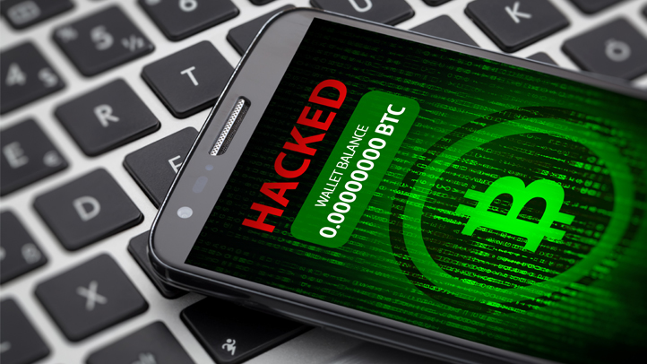 Phone laying on laptop keyboard with hacked written on phone