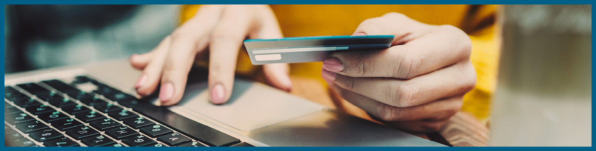close up of woman using credit card and online shopping on laptop