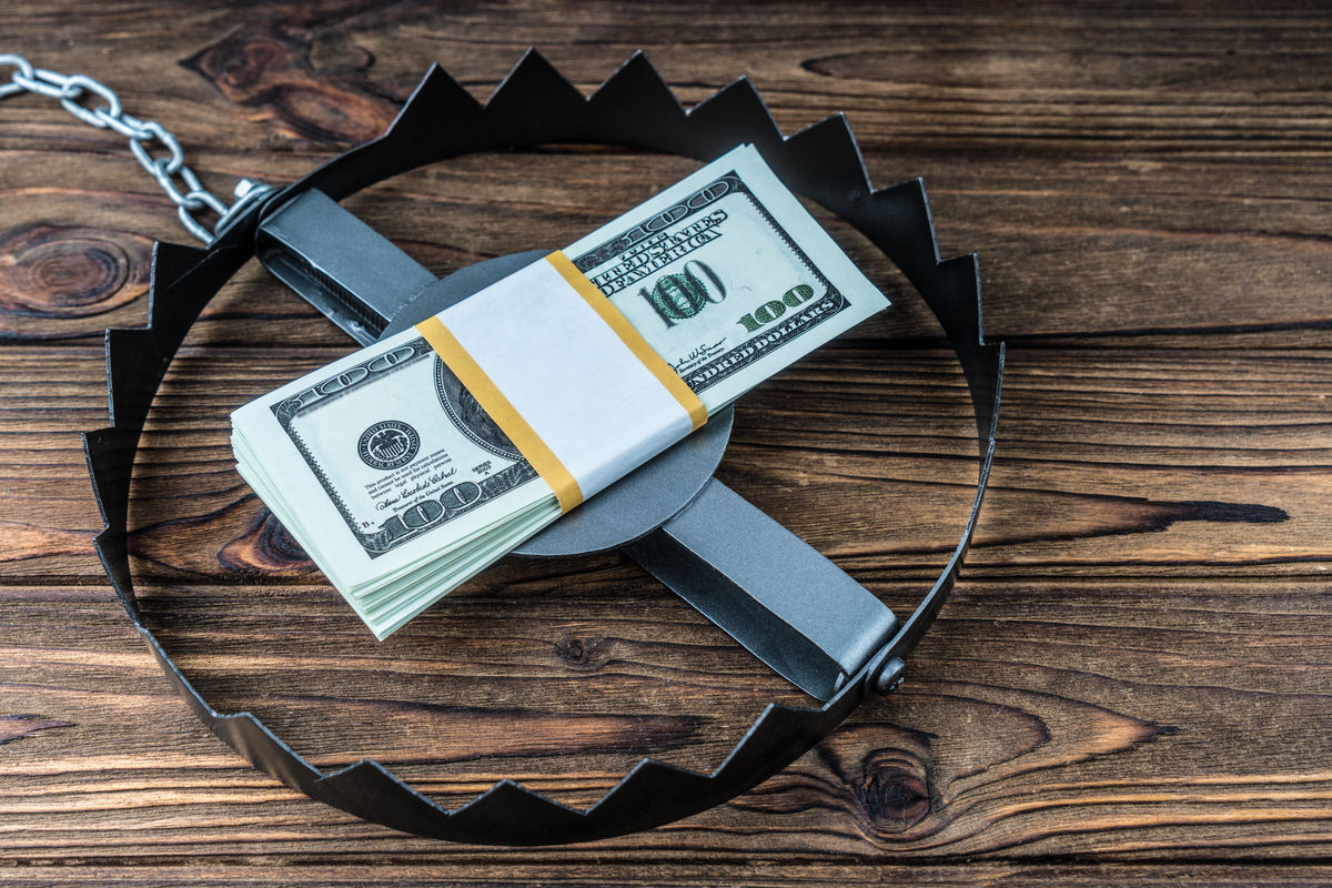 Trap with bait money dollars banknotes on a wooden background. Concept of a business situation, trick, cheating, catch on a bribe