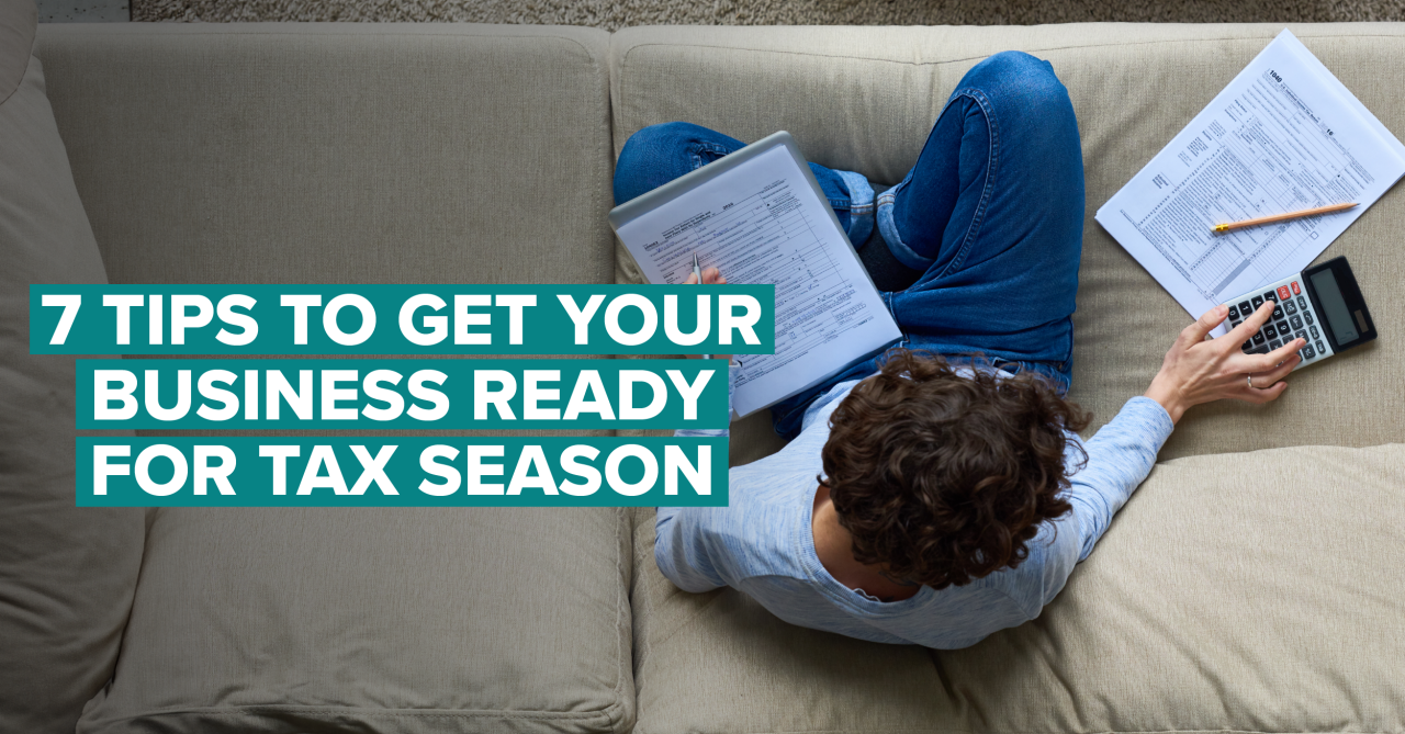 man sitting on couch looking at tax documents