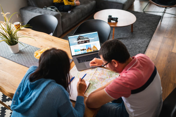 Couple Planning A Vacation Together Using Laptop