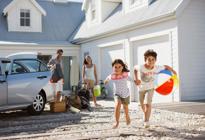 family unpacking car for beach trip