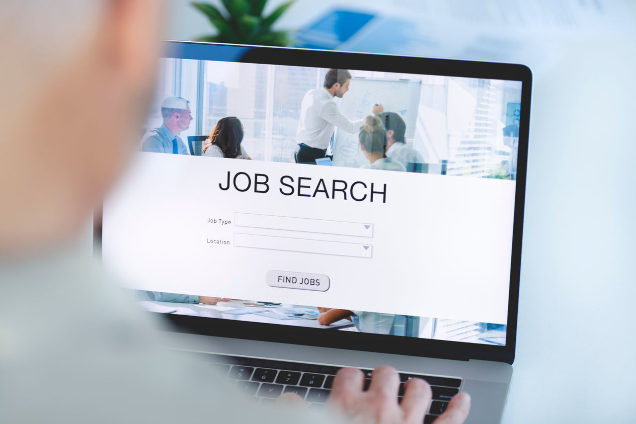 Mature Businessman looking at job search website on a laptop computer. Job type, location and Find jobs buttons