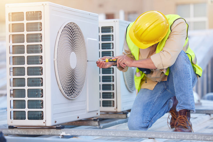 repairman works on a home's air conditioner unit 