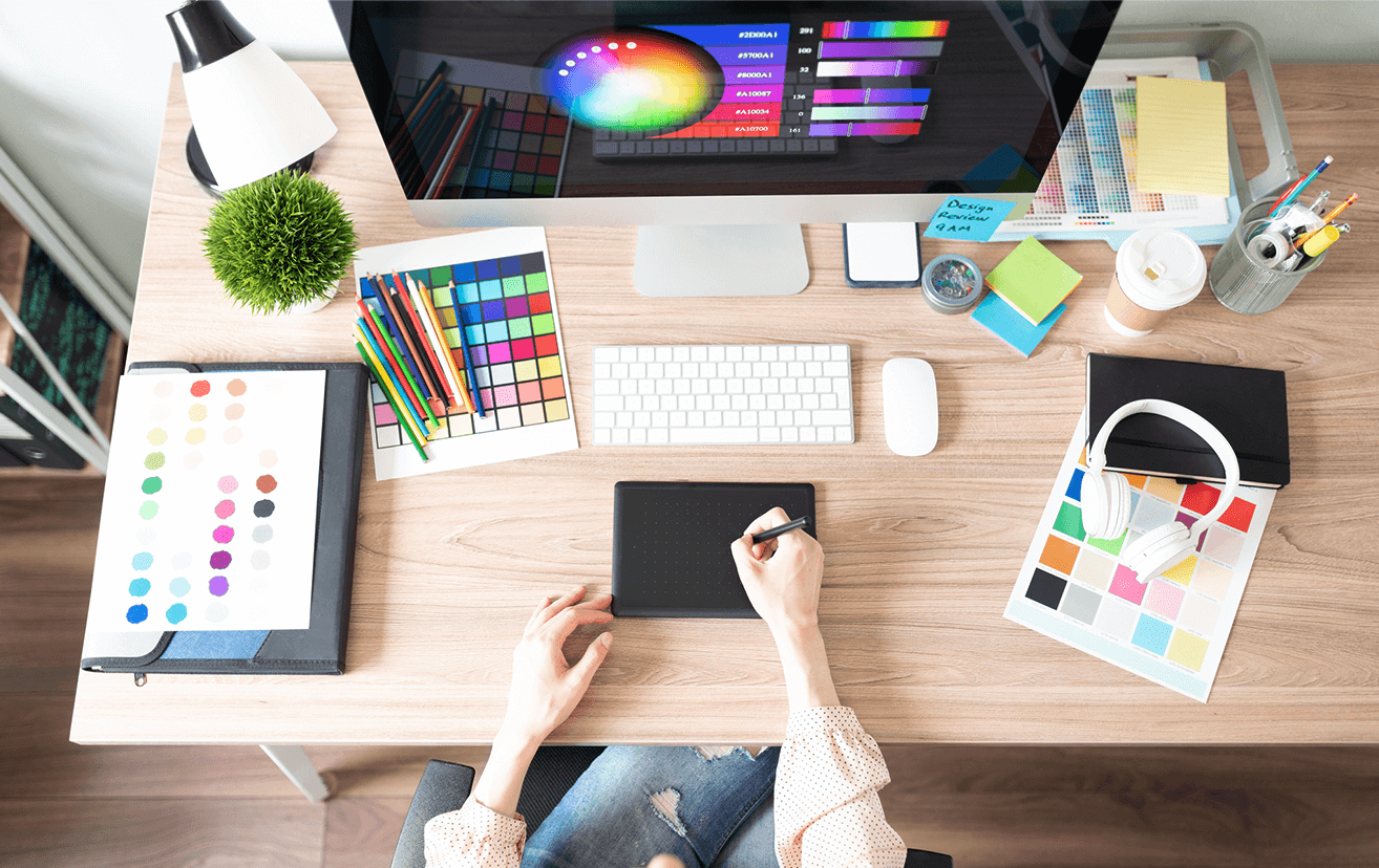 Graphic design studio desk with computer and color palettes 