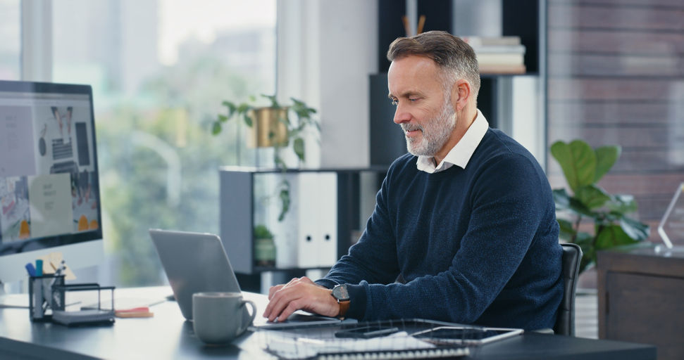 man working at desk on computer