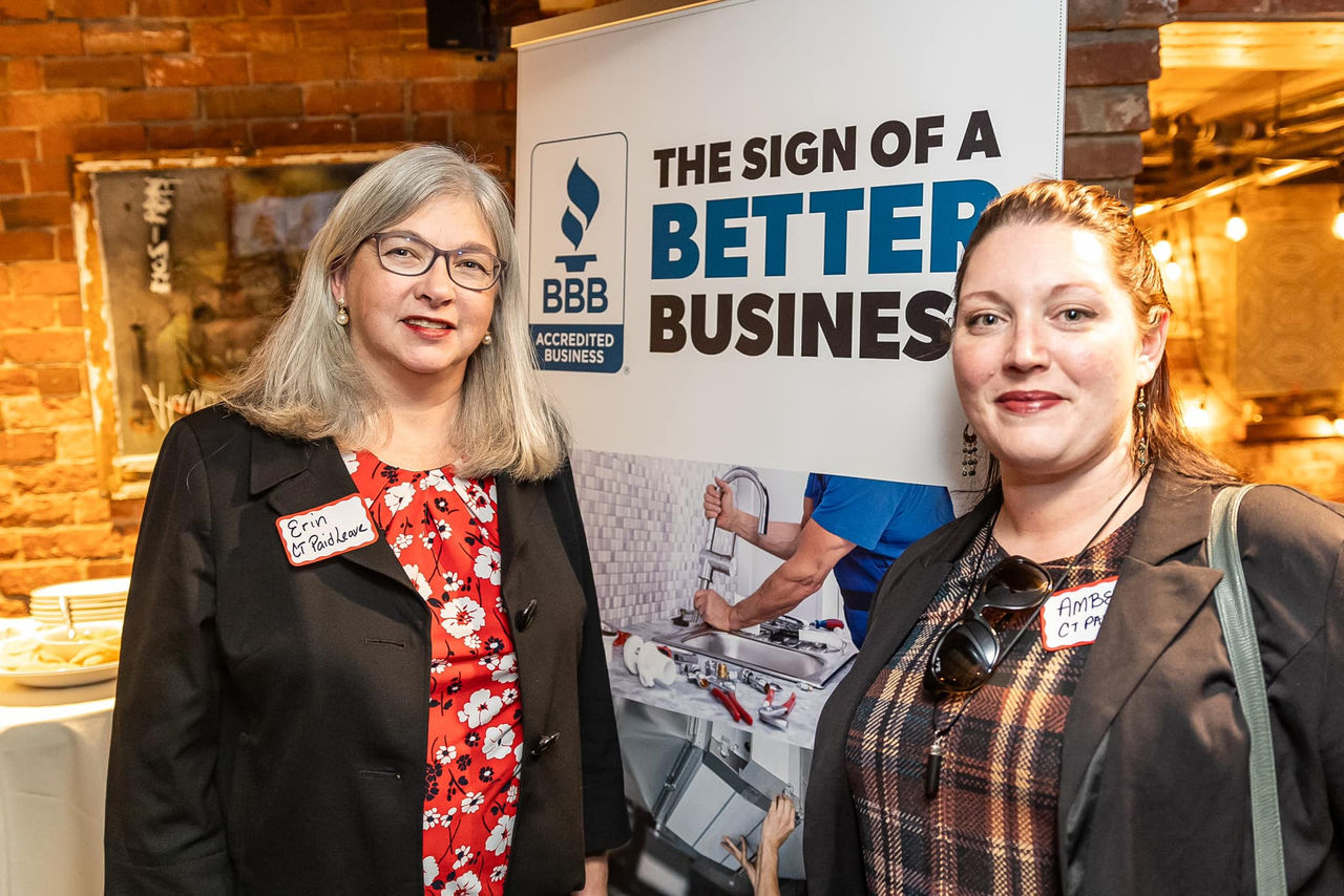 Women standing in front of BBB banner