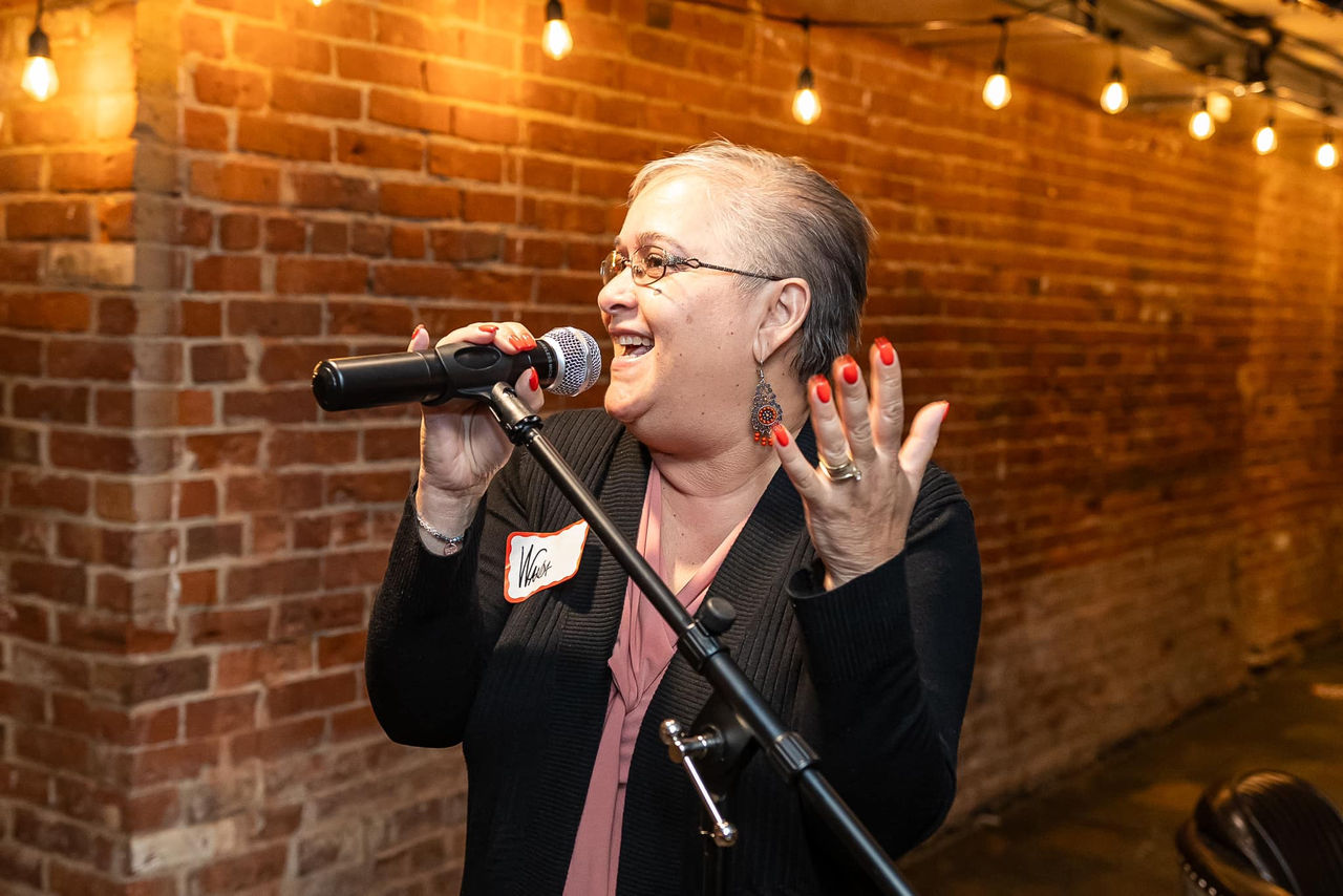 Woman speaking into a microphone at event