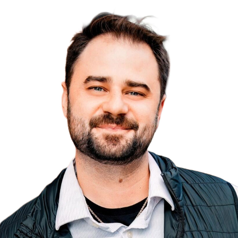 Smiling young man with brown hair and a black puffy vest