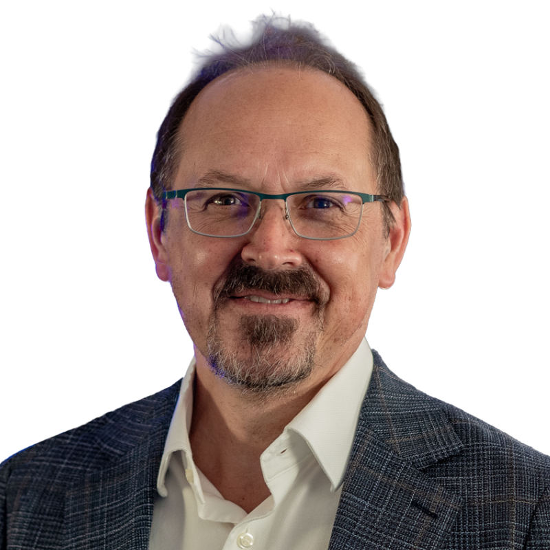 Smiling man with brown hair and glasses wearing a white shirt and plaid suite coat