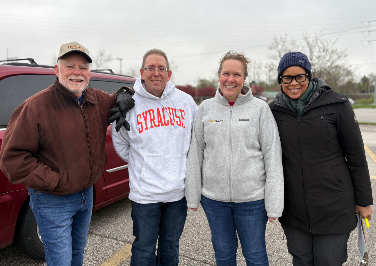 4 people standing outside smiling
