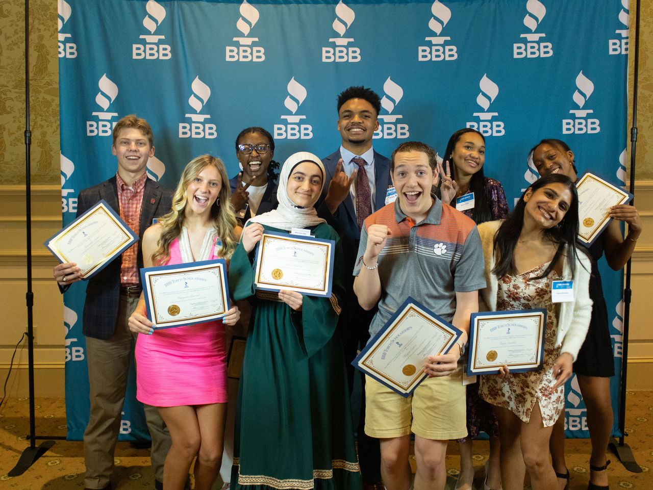 Group of smiling high school and college students holding their physical BBB Awards.