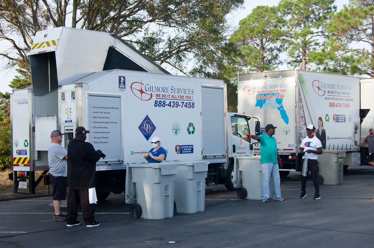 paper shredders, large trucks, workers shredding documents