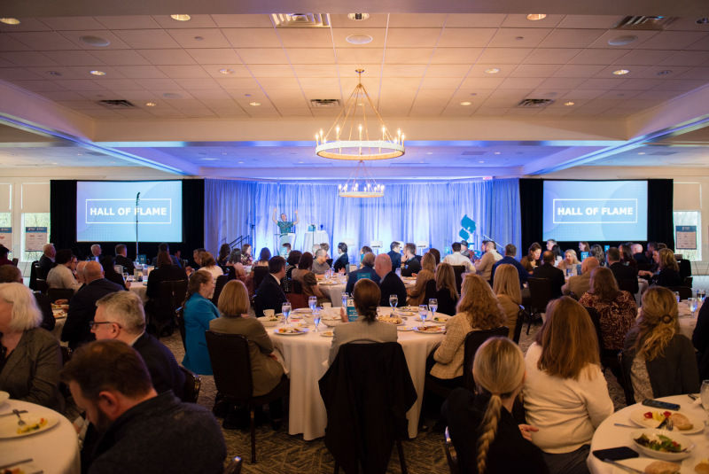 An audience sits and watches keynote speaker Tony Sanneh on stage at the 2023 BBB Torch Awards for Ethics celebration