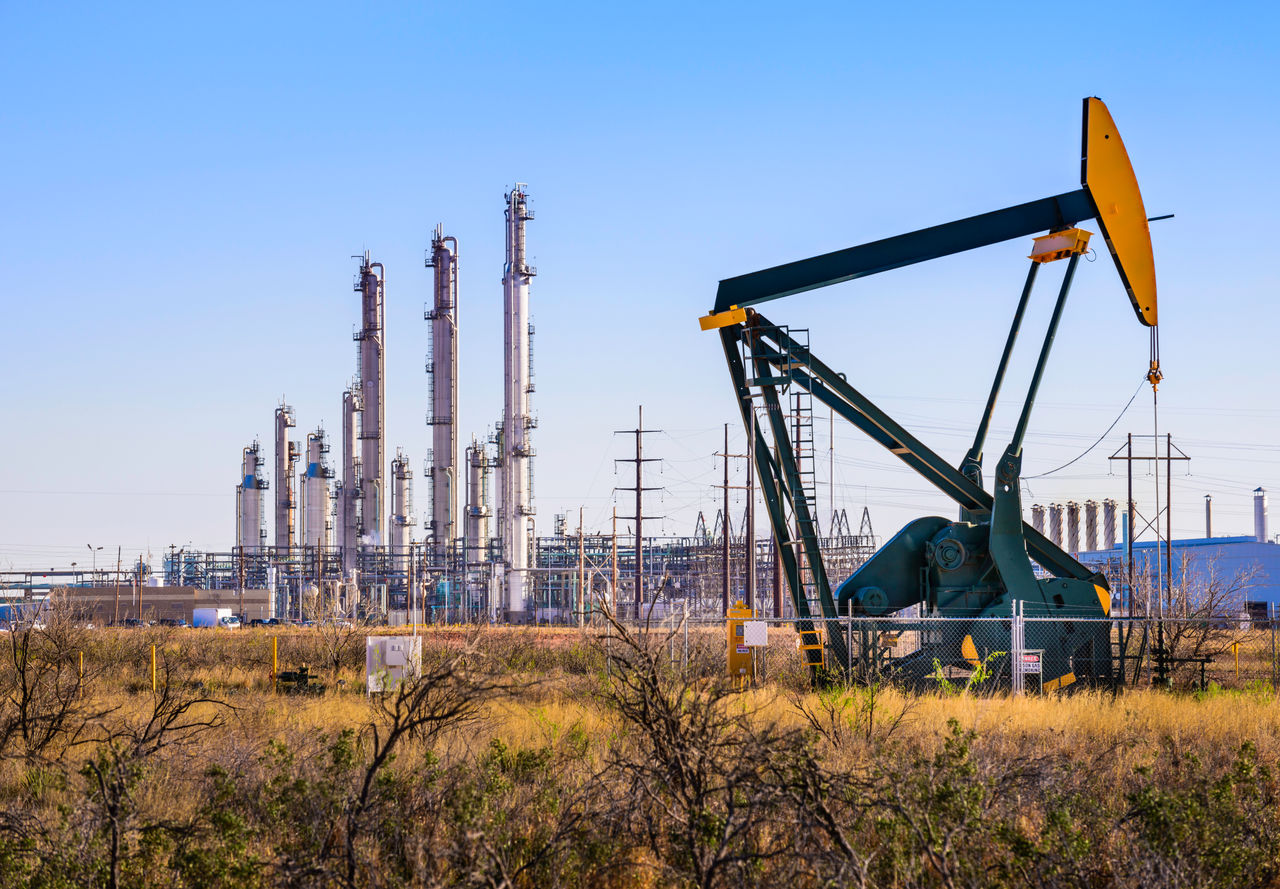 A pumpjack (oil derrick) and oil refinery in Seminole, West Texas.