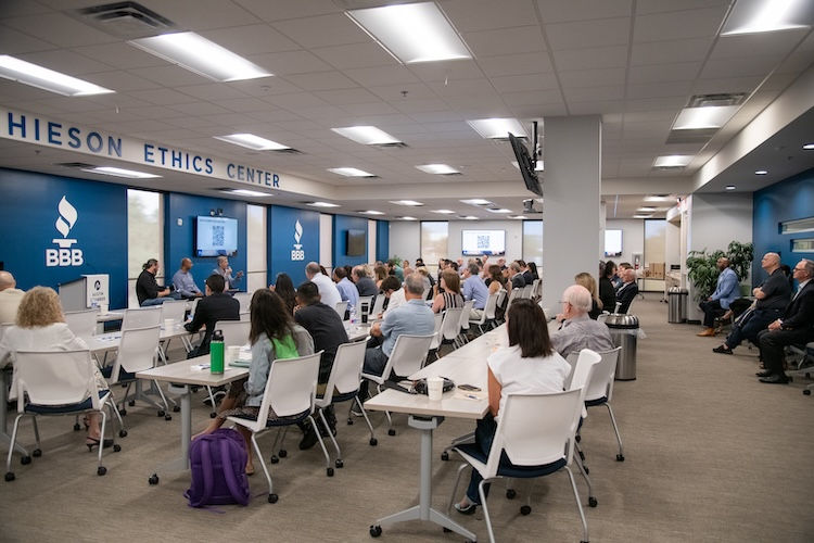 panel of speakers talking to room of attendees