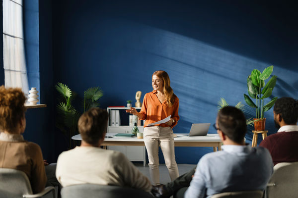 Happy businesswoman leading an education event in front of her colleagues in the office.