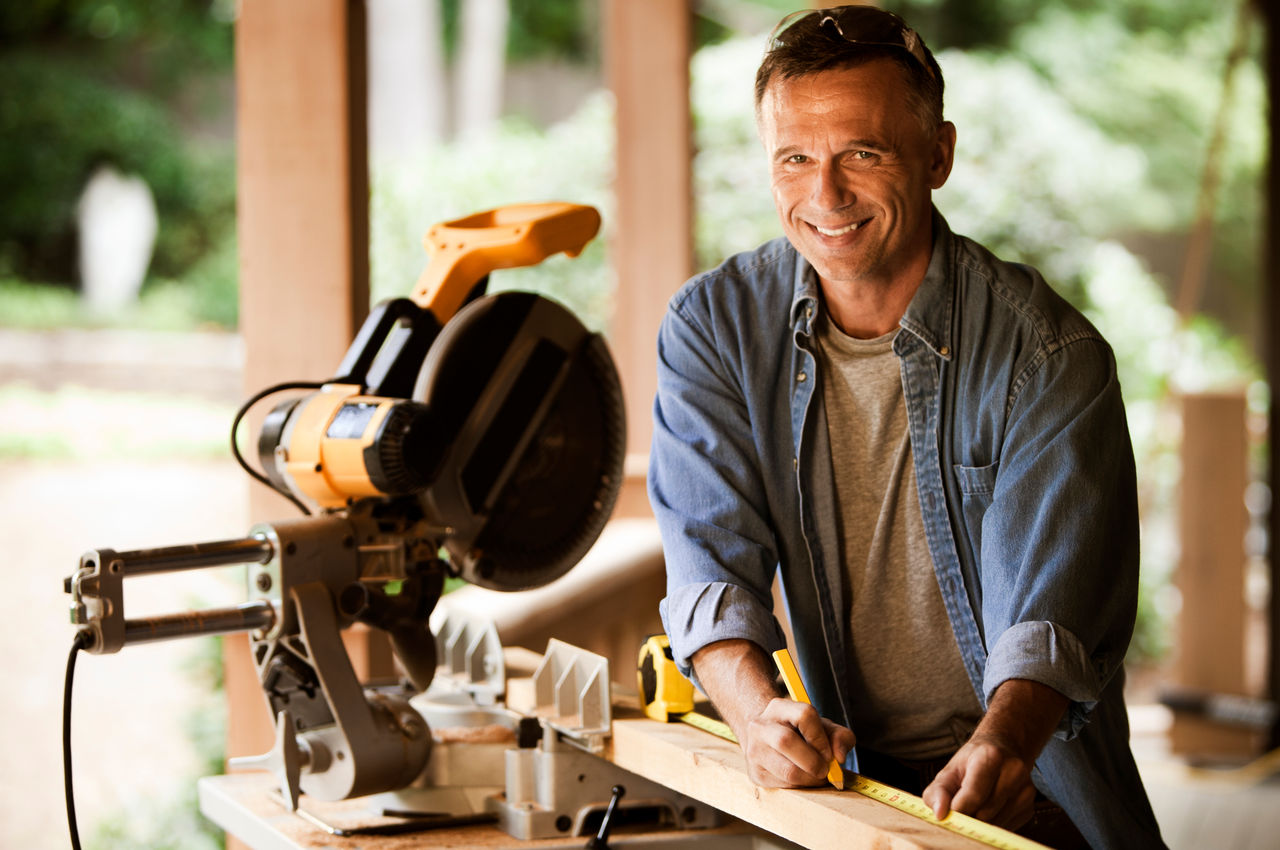 Carpenter making a measurement on a board.