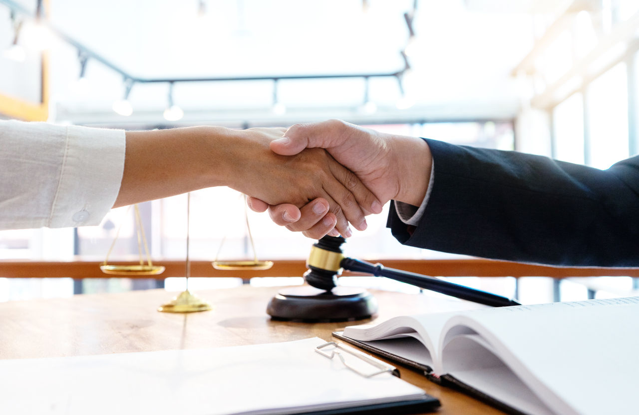 Lawyer or judge  with gavel and balance handshake with client or customer about agreement how to  use arbitration       handshake