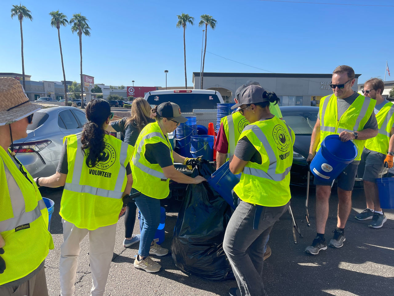 men and women in neon yellow vests disposing of trash