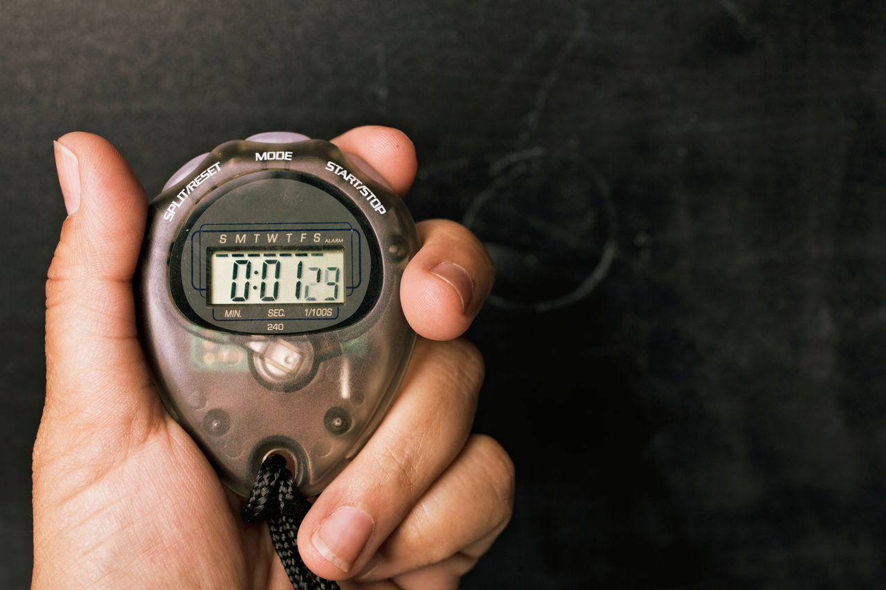Coach holding up a stopwatch.