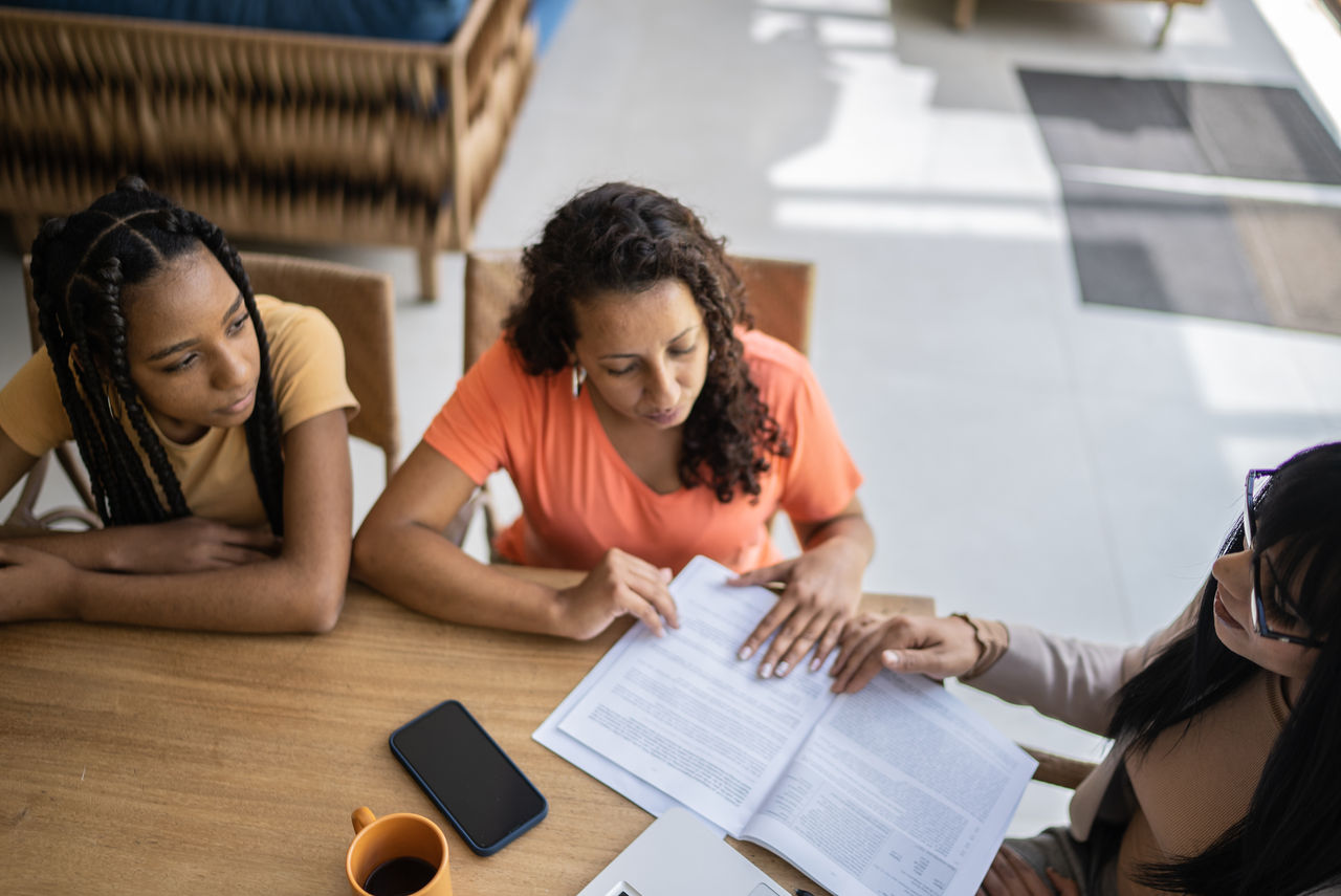 Professional consultant talking to a mother and daughter during a home visit