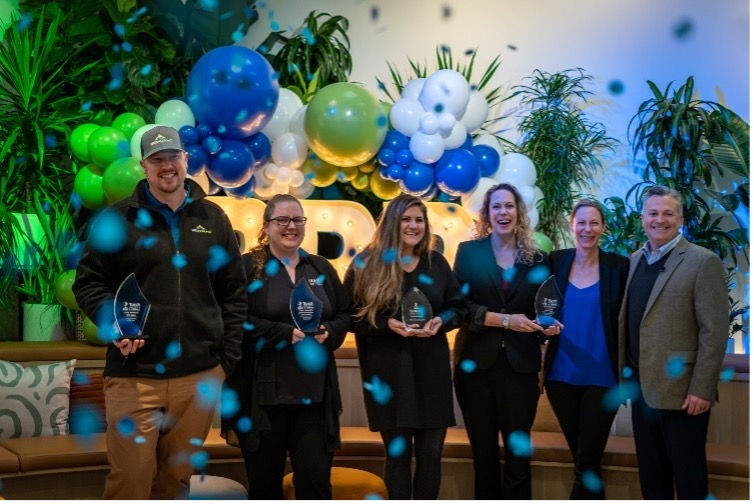Group of people receiving award with balloons and confetti