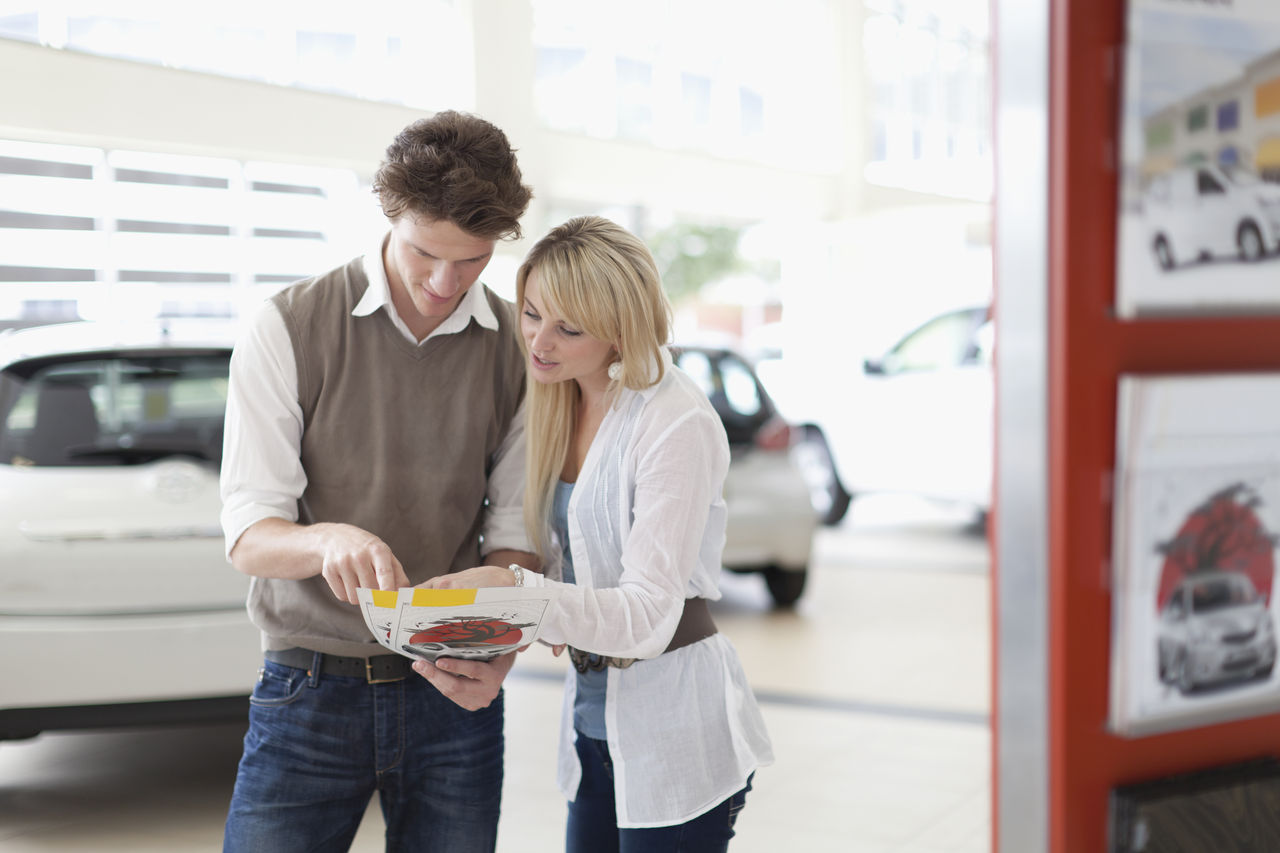 couple comparing vehicles at car dealership