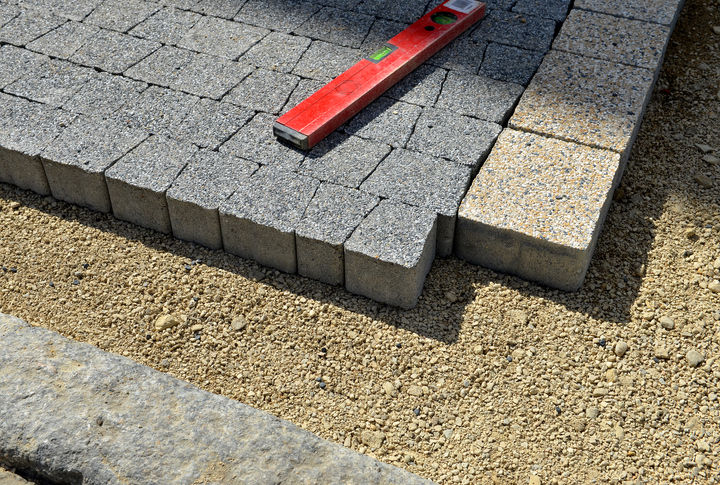 Man planting flowers in yard, dressing up landscape in front of brick wall