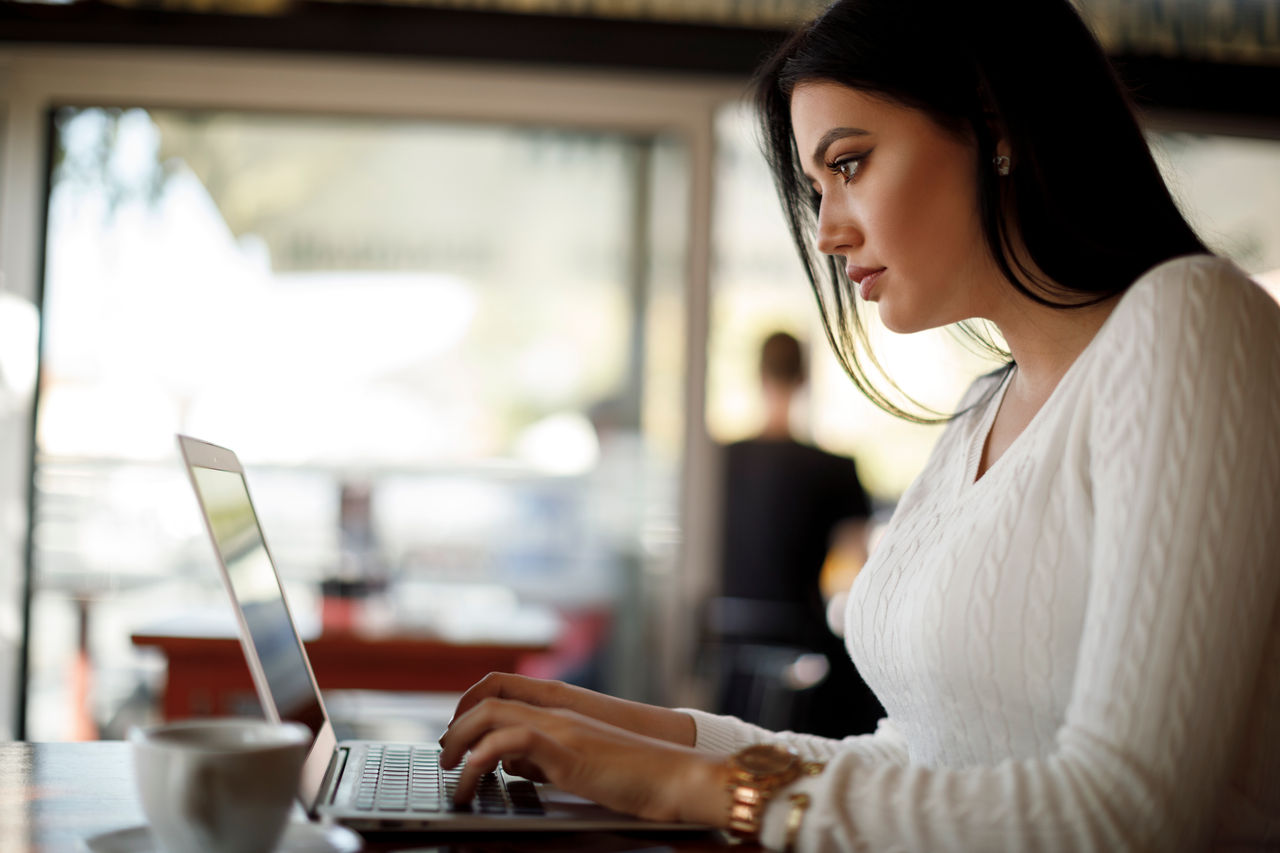 Young woman using laptop at a cafe