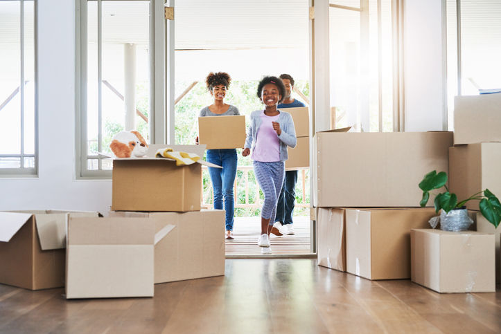 Shot of a happy family carrying boxes into their new home