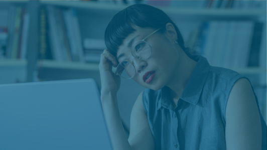 woman with worried look looking at computer screen with blue overlay