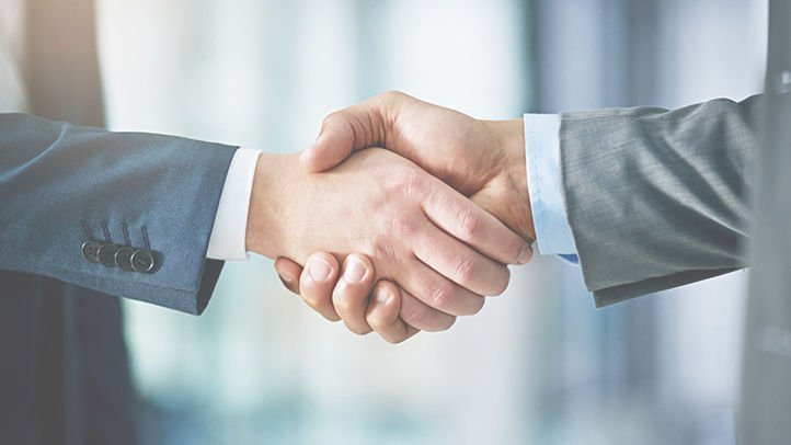 Closeup shot of two businessmen shaking hands in an office