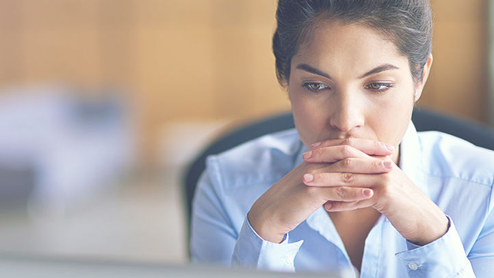 Shot of a young businesswoman looking stressed while working on her laptop