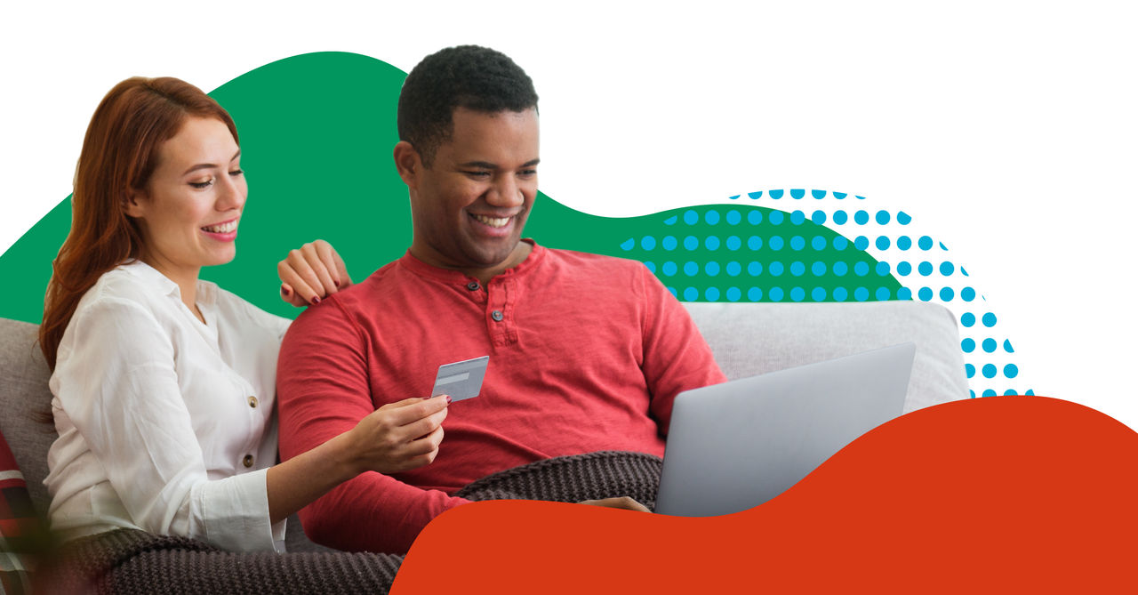 interracial couple sitting on couch online shopping together